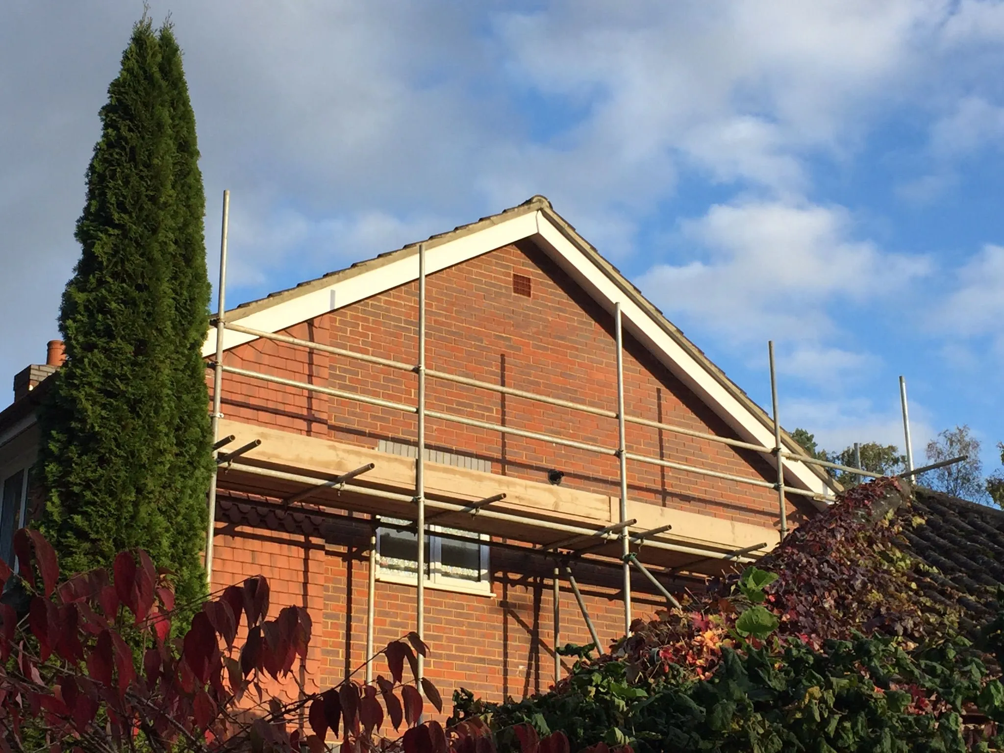 A house under construction with scaffolding on the roof.